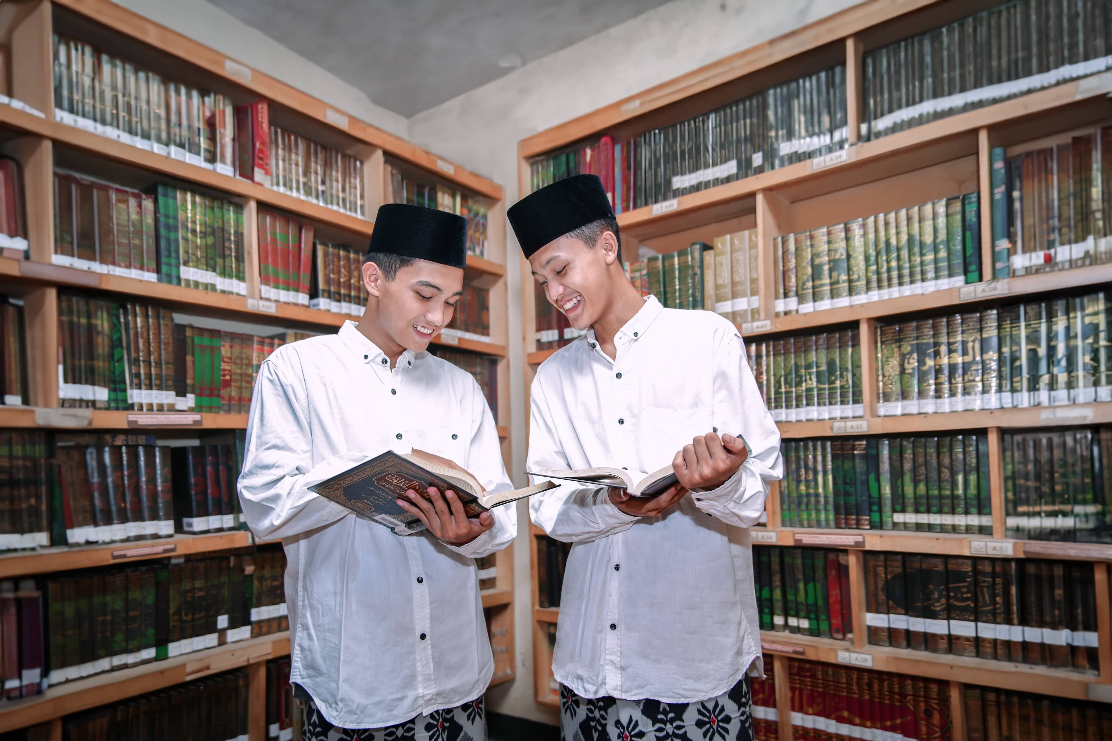 Foto dua santriwan sedang membaca kitab di perpustakaan